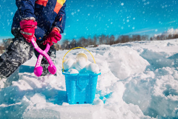 child making snowballs in winter nature, kids play outdoors