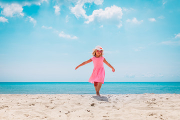 happy cute little girl dance play on tropical beach