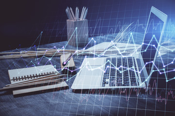 Double exposure of graph and financial info and work space with computer background. Concept of international online trading.