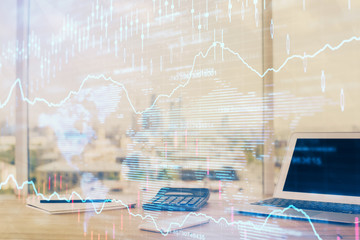 Forex graph hologram on table with computer background. Multi exposure. Concept of financial markets.