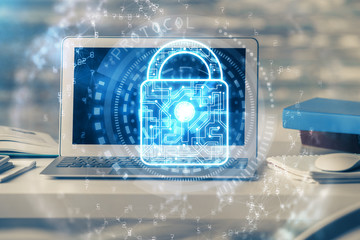 Double exposure of desktop with computer and lock icon hologram. Concept of data safety.