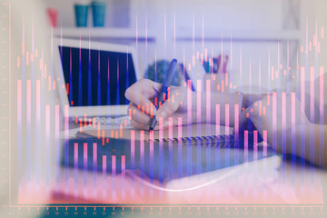 Financial graph displayed on woman's hand taking notes background. Concept of research. Double exposure