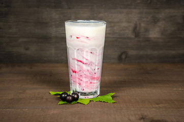 Glass of yoghurt cocktail, smoothies, with raspberries stands on a birch stump, on wood background.