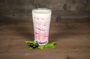 Glass of yoghurt cocktail, smoothies, with raspberries stands on a birch stump, on wood background.