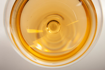 Glass of white wine with shadow. Top view. Abstract red wine bubbles.