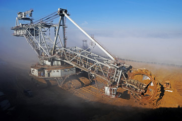  A huge bucket-wheel excavator on the open-pit mine. Excavator in the fog.