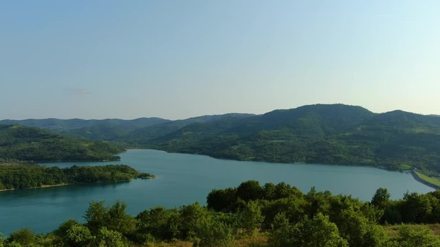 Lake Butoniga water reservoir dam in Croatia wide angle panorama forward approach, Aerial drone flyover shot