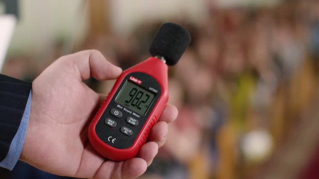 Decibelometer close-up. Stock footage. Measurement of sound volume in the audience. Experiment. Sound level meter