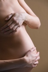 Pregnant Woman Covering Breast And Tummy