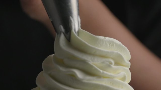 Hand piping whip cream with a piping bag.