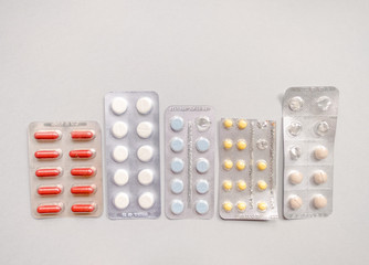Tablets in packs. Tablets on a light background. Different types of pills