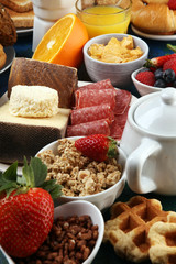 Breakfast served with coffee, orange juice, croissants, cereals and fruits. Balanced diet. Continental breakfast with granola and fruits