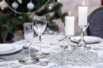 Set Christmas table for two person in cosy living room in silver colors