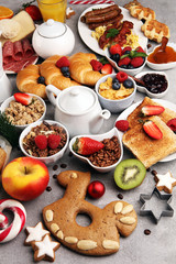 Fototapeta na wymiar Breakfast served with coffee, orange juice, croissants, cereals and fruits. Balanced diet. Continental breakfast on christmas