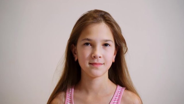 A young girl looks at the camera and smiles.