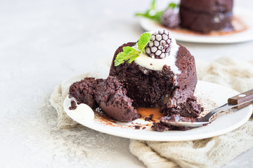 Warm dessert chocolate fondant with ice cream, mint and blackberry on the white plate. Lava cake recipe. Perfect dessert for Valentine’s Day.