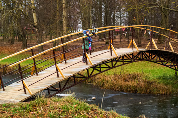 a little girl of 7-8 years old walks along the Garbat bridge, selective focus with shallow depth of field, warm vintage filter