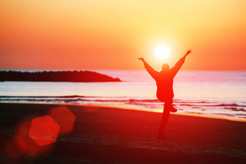 Silhouette a man, exercise on the beach at sunset.