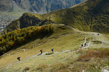 Kazbegi, Georgia - September 18, 2018: Group of tourists is hiking to Gergeti Trinity Church (Tsminda Sameba), Holy Trinity Church near Stepantsminda village (Kazbegi) in Georgia © Andrey Vlasov