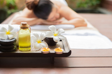 Obraz na płótnie Canvas Spa massage therapy setting , nature product towel salt with candles and black hot stone on wooden with blurred people background , Spa beauty treatment relaxation concept