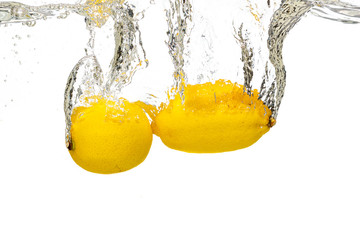whole lemon, half and sliced slices falls under water