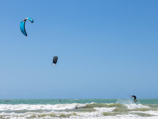 kite surfing in the sea with windmills in the background