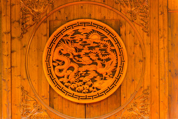 Fototapeta na wymiar Carving of Chinese dragon and phenix on a wooden door