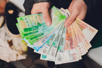 Rubles in hands. Stack of money. Black background.