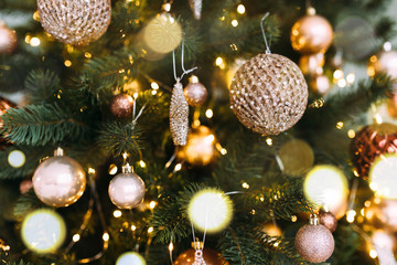 Obraz na płótnie Canvas Close-up Christmas tree with beautiful golden Christmas tree decorations on Christmas Eve