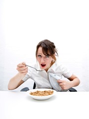 Portrait of young businesswoman ironing her shirt white having breakfast at table