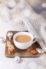 White cup with coffee and marshmallow, sweater, cinnamon. Cozy christmas composition. Hygge concept Soft focus