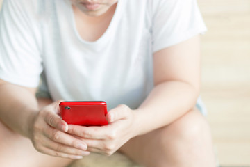 Close up image of a woman using a red smartphone