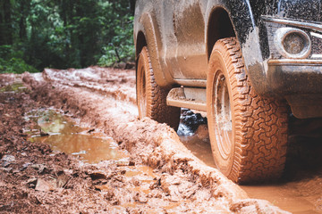  Dirty offroad car, SUV covered with mud on countryside road, Off-road tires,  offroad travel  and driving concept.