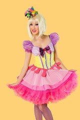 Portrait of young woman in doll's costume posing against yellow background