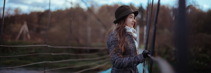 Young woman on a large suspension bridge in the village.