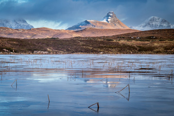 Stac Pollaidh in winter seen across a frozen loch