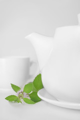 Teapot and cup decorated mint leaves