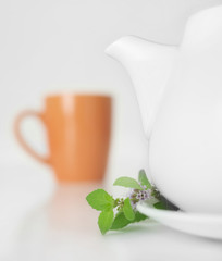 Teapot and cup decorated mint leaves