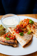 Delicious Mexican quesallidas made with chicken, tomato pieces and served with guacamole sauce.