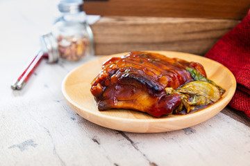 Chinese lacquered pork slices with its caramelized sauce prepared for eating in a wooden plate