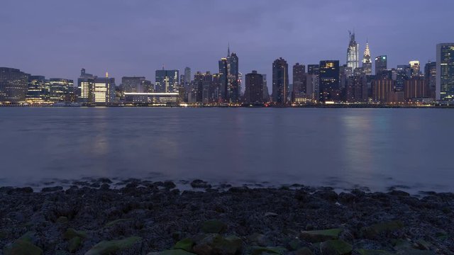 Night to day time-lapse Midtown Manhattan from East river beach