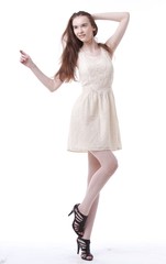Naklejka premium Beautiful young woman in dress with hand in her hair looking away against white background