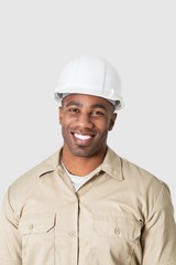 Portrait of happy young African male construction worker over gray background