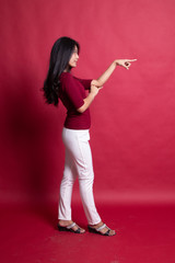 Full body side view of beautiful young asian woman pointing.