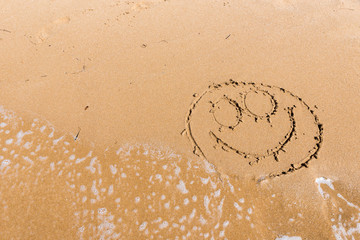 Smile draw on the shore of the sea