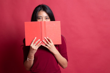 Fototapeta premium Young Asian woman with a book cover her face.