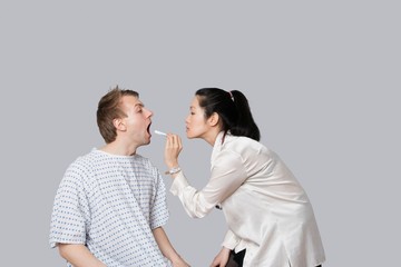 Female doctor examines patient's throat