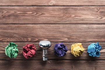 Ideological concept with wastepaper light bulb on wooden table