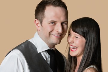Portrait of cheerful young couple over colored background