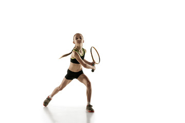 Fototapeta na wymiar Little caucasian girl playing tennis on white studio background. Cute model training, practicing in motion, action. Youth, flexibility, power and energy. Movement, ad, sport, healthy lifestyle concept